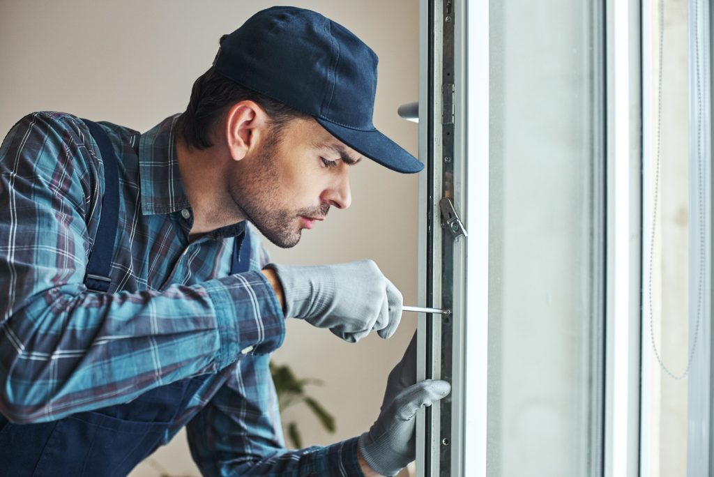 Master's work. Close-up of young handyman setting new windows